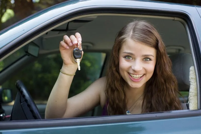Happy young female student holding car keys after passing Alberta Class 5 road test — Orchard Driving School