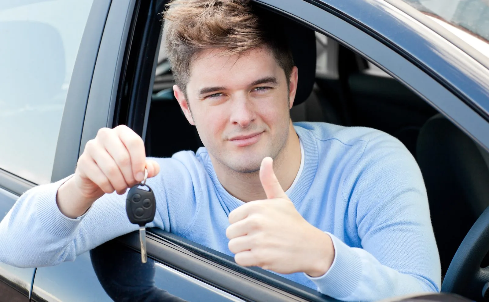 Happy student holding car keys after passing Alberta road test at Orchard Driving School Edmonton