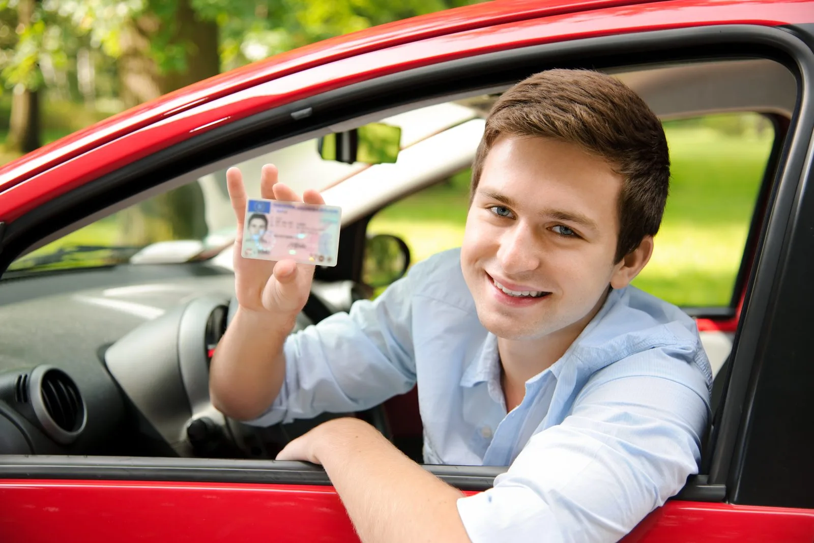 Young female student showing driver licence and car keys after passing Alberta road test first try